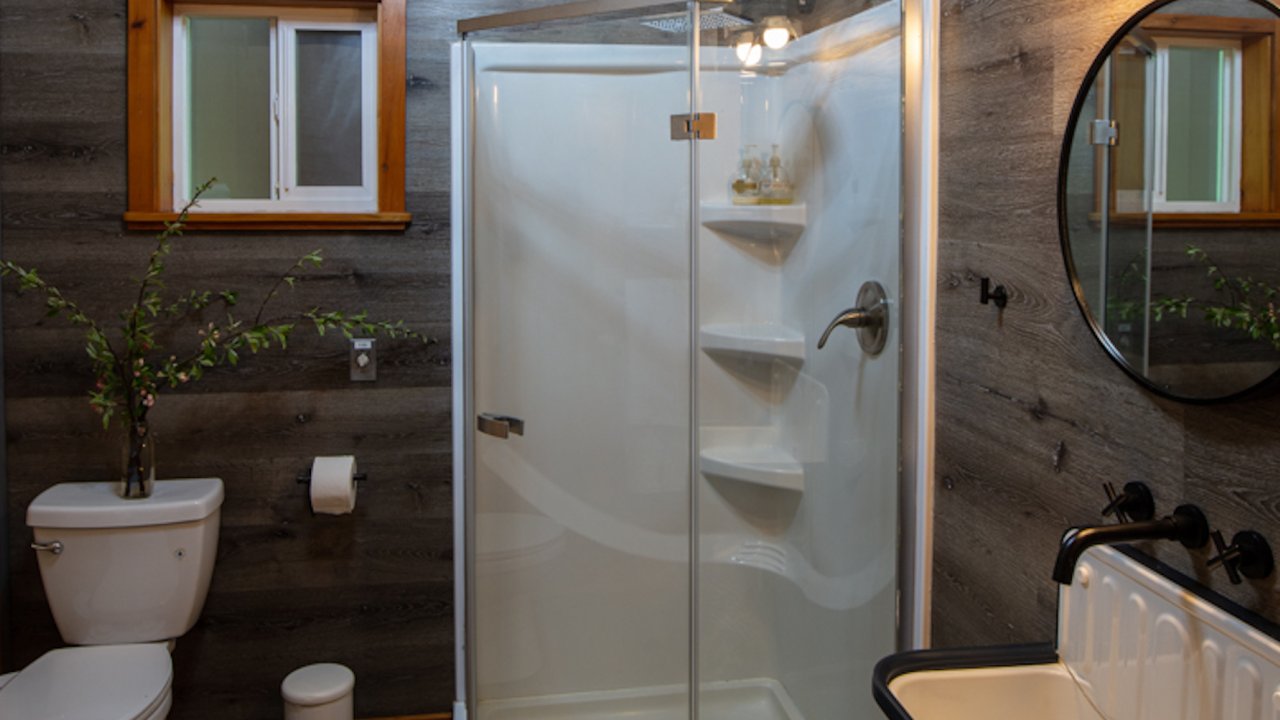Bathroom with sink, mirror, glass shower, and toilet in one of the cabins at Half Moon Bar Lodge in Oregon