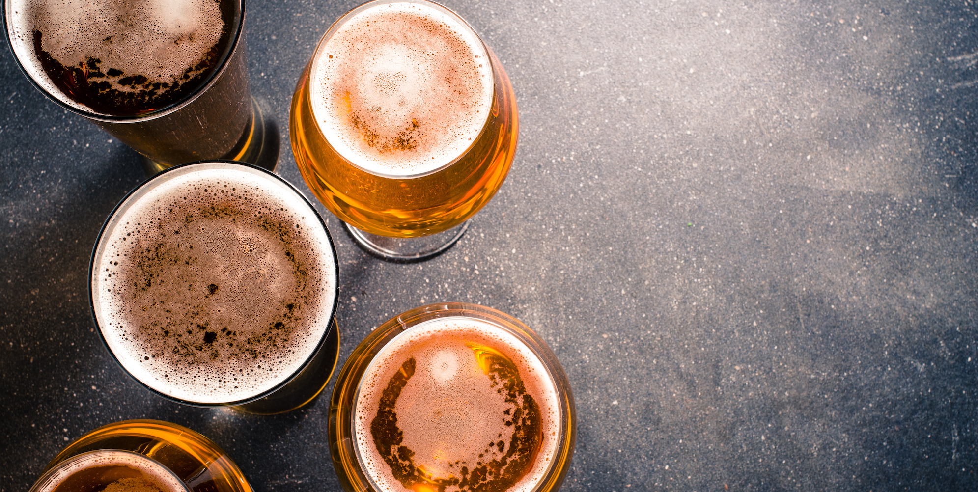 Top down view of four pints of beer in glasses