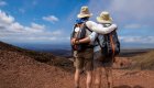 people arm in arm overlooking a volcano while on a hike