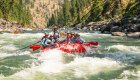 A group of people in a red paddle raft in the middle of a rapid on the Main Salmon River