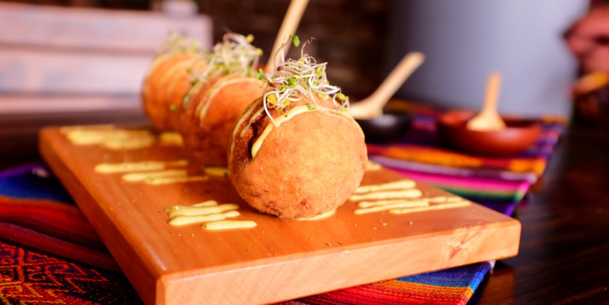 Bolon de verde topped with micro green on a wooden cutting board ready to be served