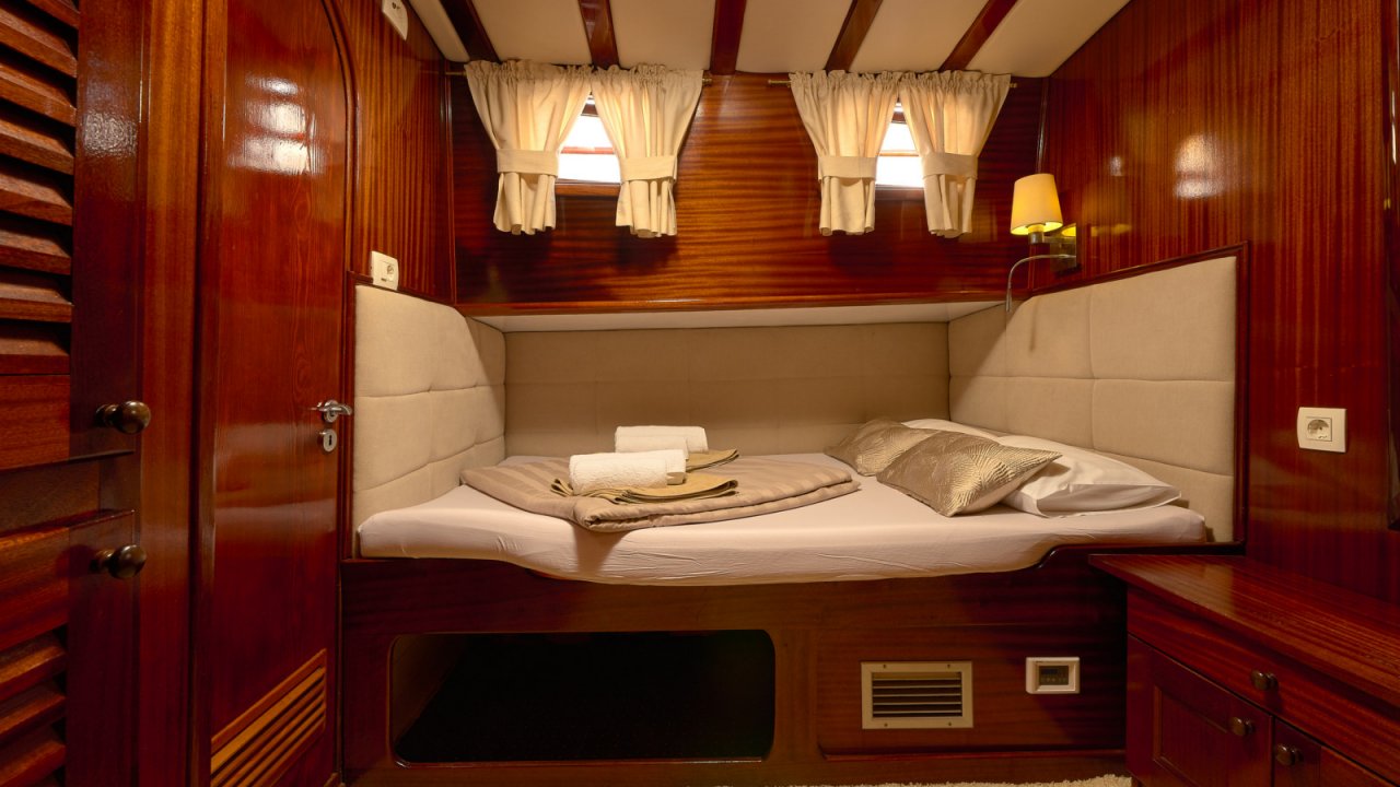cabin with wood paneling and bed on board a yacht