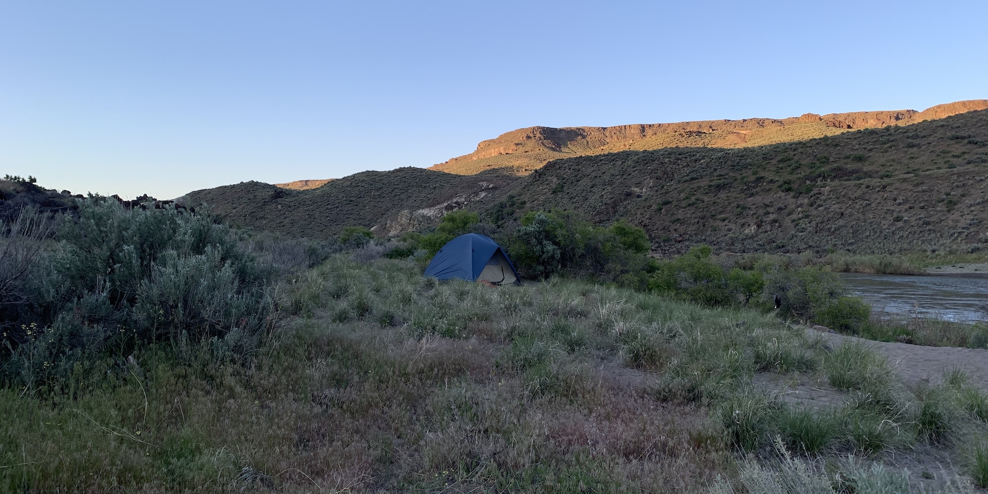 A tent set up in a beautiful field outside of Jordan Valley, Oregon.
