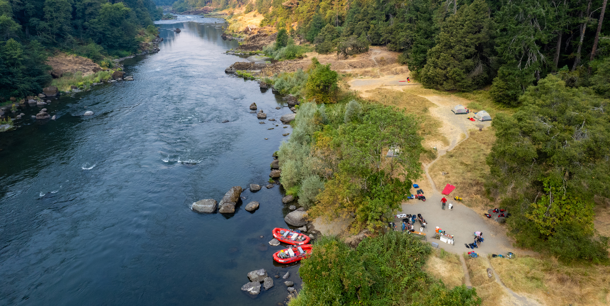 Birds eye view of a camp site set up on a sandy beach along the Rogue River Corridor