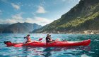 A couple sea kayaking on calm waters outside of Corsica.