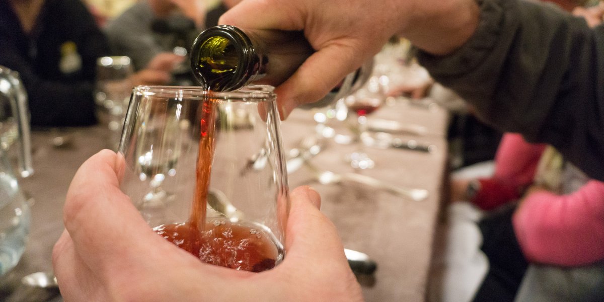 Pouring red wine into a wine glass out to dinner in Corsica