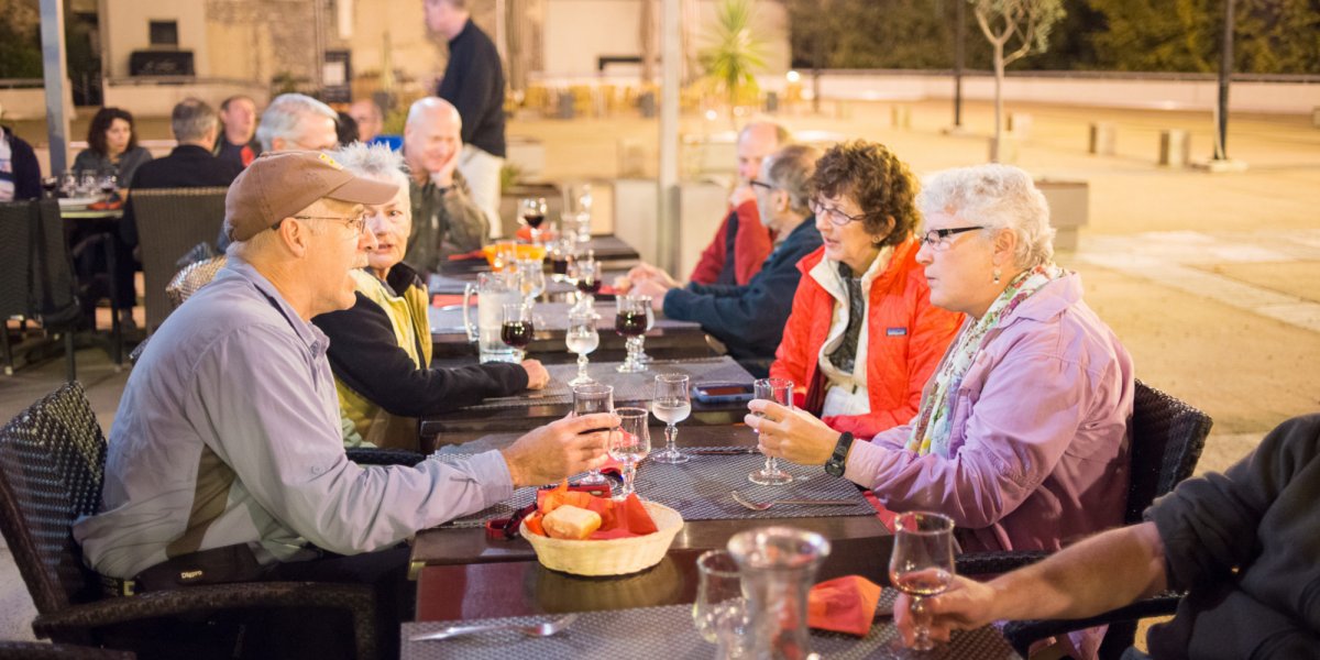 Guests enjoy an evening dining and drinking together on a Corsica Hiking trip.