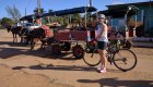 Woman with her bike next to mule traffic in Cuba