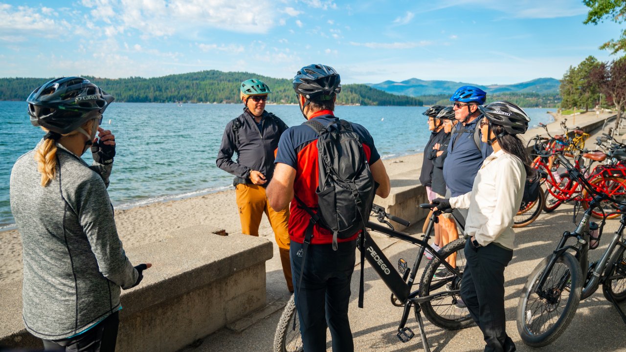 A group of people standing around their bikes in Northern Idaho on a sunny day