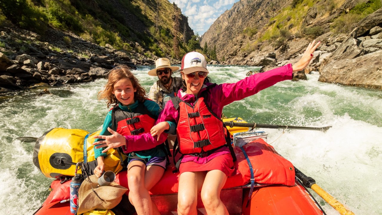 Family rafting through whitewater rapids with a guide in Idaho.