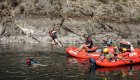 A person jumping off of a red ROW Adventures raft while on a rafting adventure in Idaho.