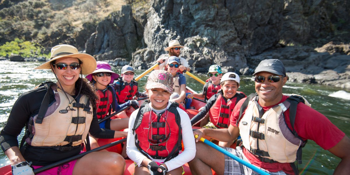 a family posing for a picture while river rafting