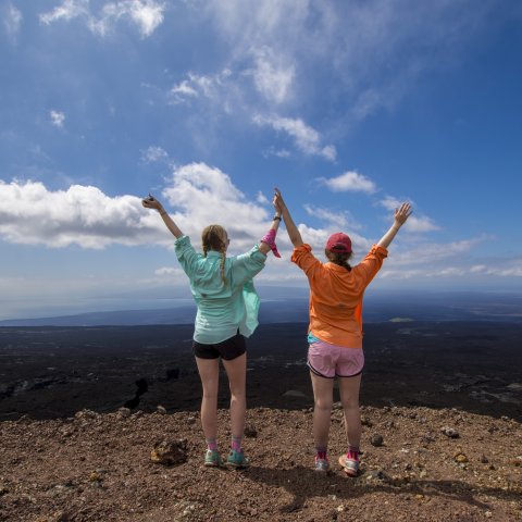 A mom and daughter overlooking a volcano while on a hike in the Galapagos Islands