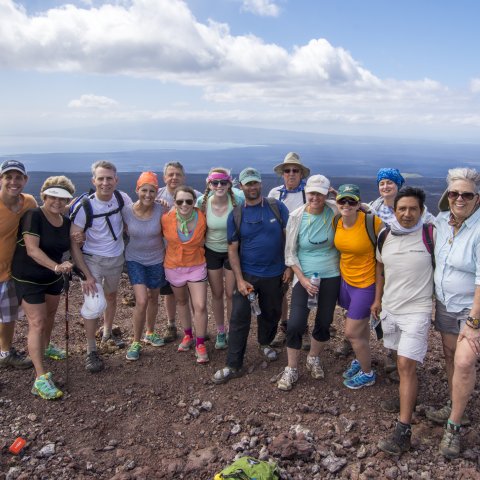 A group of tourist stop for a photo while hiking the volcano in the Galapagos