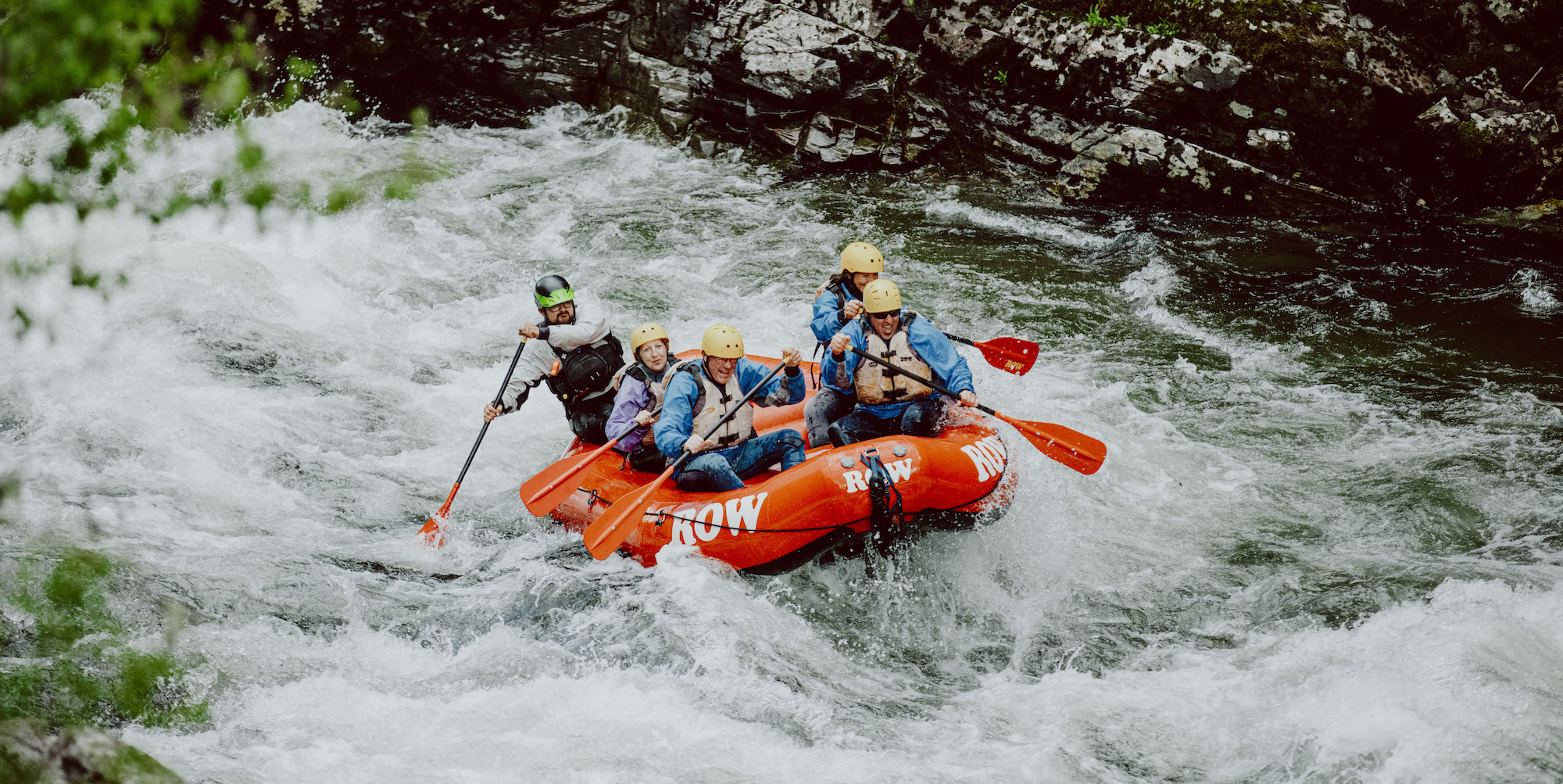 A group rafting trip in a red raft going down the St. Joe River in Northern Idaho