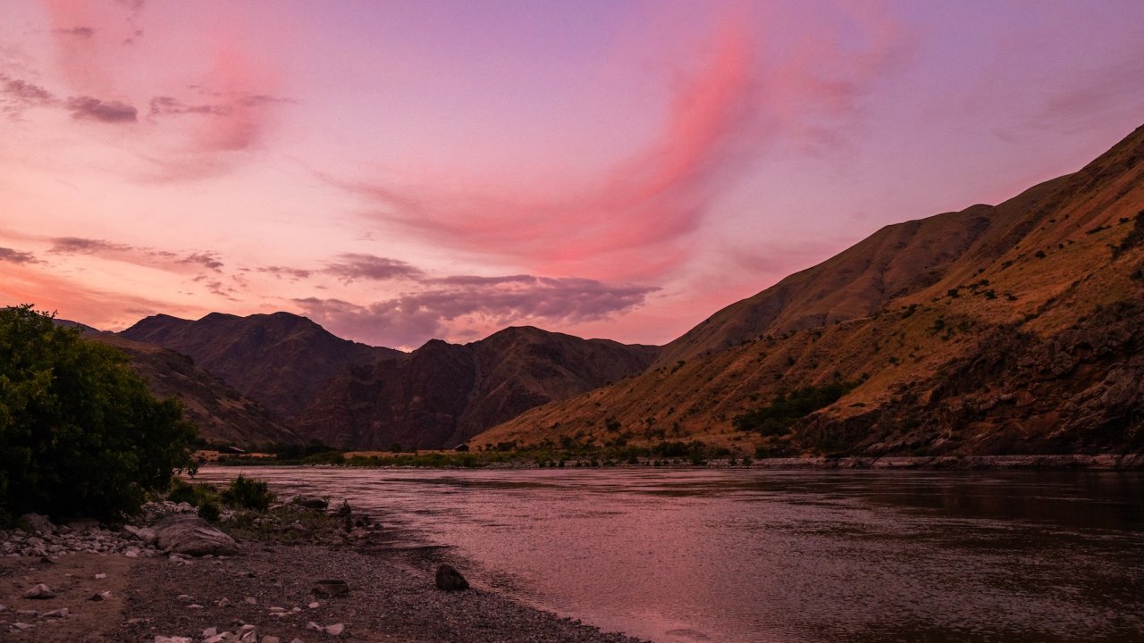 A pink Idaho sky as the sun sets over the Snake river in Hells Canyon.