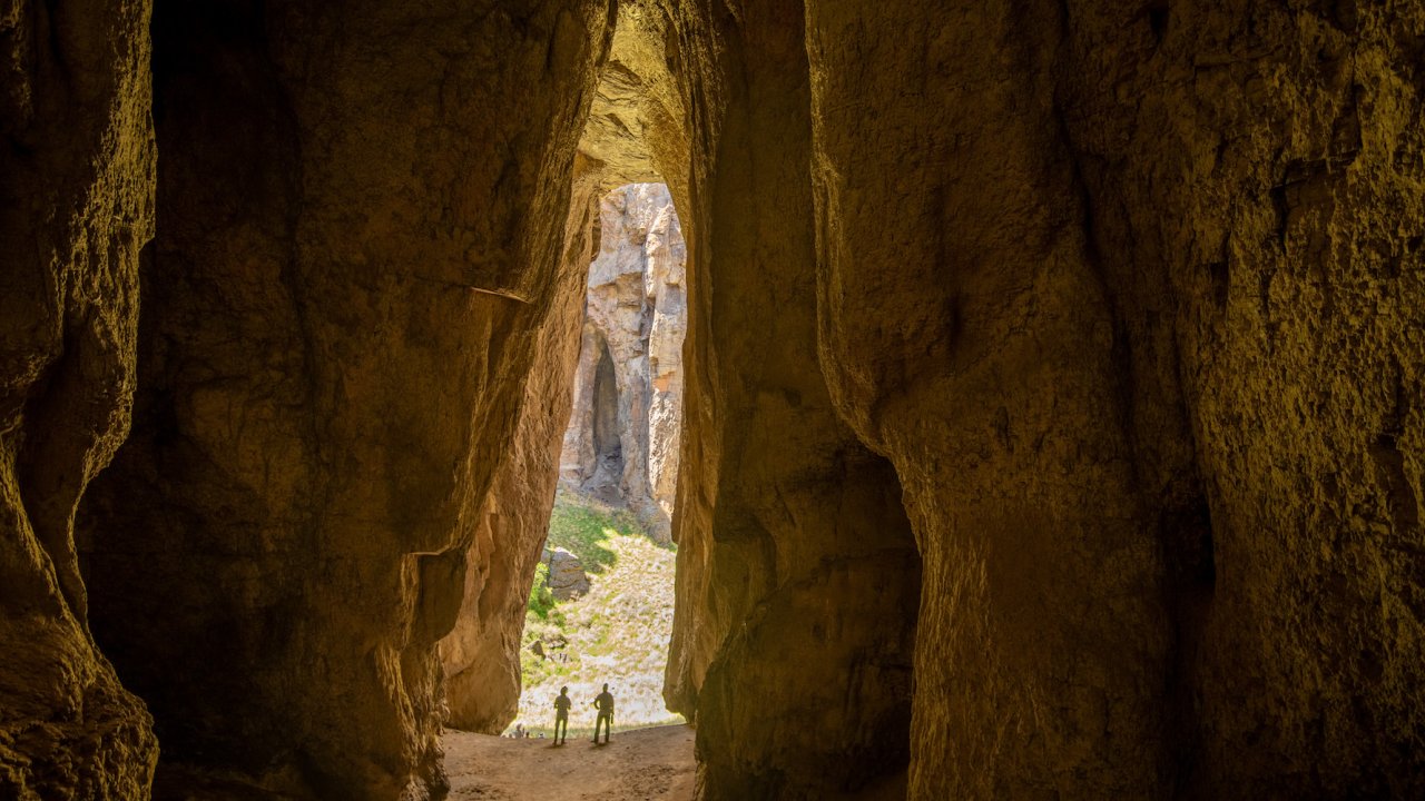 The shadow of two people in an open oval of space between towering canyon walls in Idaho