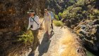 People walking along the Rogue River wilderness trail in Oregon on a sunny morning