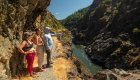 Three people observing something from a viewpoint on a hike