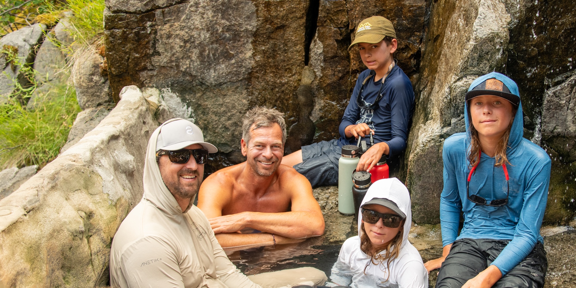 Group relaxing in natural hot springs along the Main Salmon River during a Salmon River rafting expedition