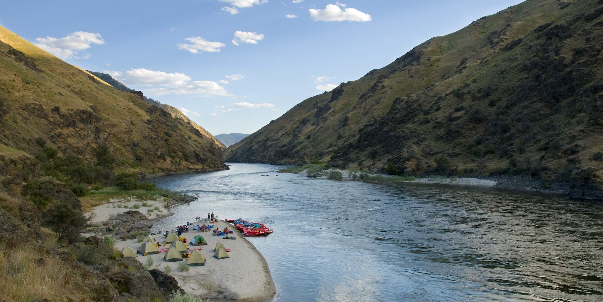 Panoramic view of a sandy beach camp set up along Idaho's Salmon River Canyons