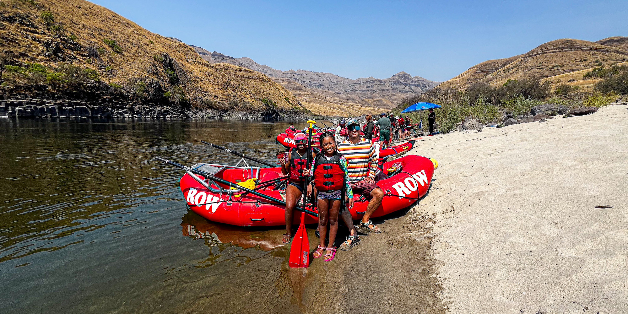 Dineo Dowd and the Wisconsin Adventure Family pause for a photo in front of a red ROW raft along the Lower Salmon River