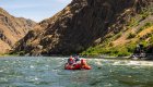 Rafters navigating scenic canyon waters in Idaho, combining whitewater adventure with the restorative spirit of a wellness retreat.