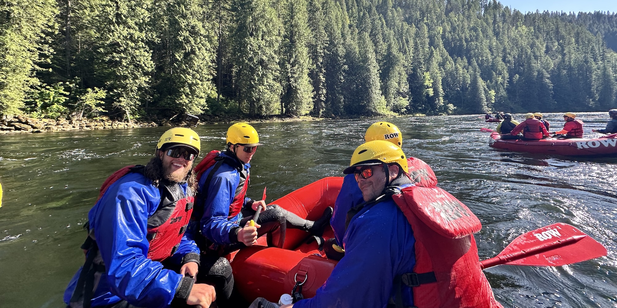 Group of guests on a red ROW raft after going though a whitewater rapid.