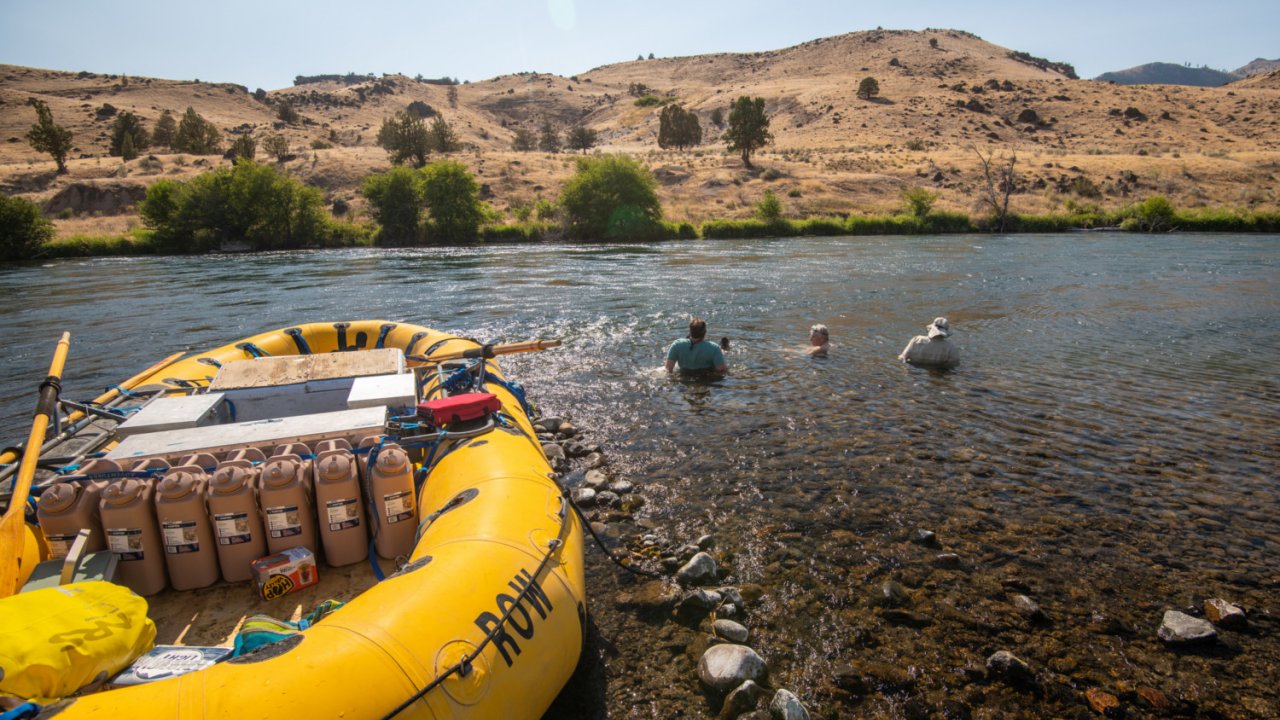 yellow raft with gear riverside