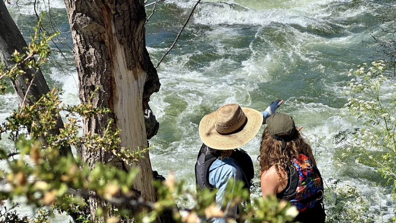 Two women scouting a class IV rapid on the Deschutes River in Oregon