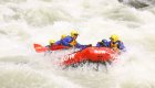 huge whitewater with a red raft in the middle