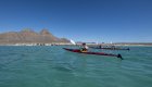 Group sea kayaking in Loreto, Baja Mexico, with turquoise waters and rugged desert mountains in the background during a guided Mexico kayak tour.