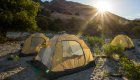 Tents on a sandy beach near the shores of the Salmon river during sunrise.