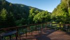 Deck with plastic chairs overlooking the forested Rogue River wilderness