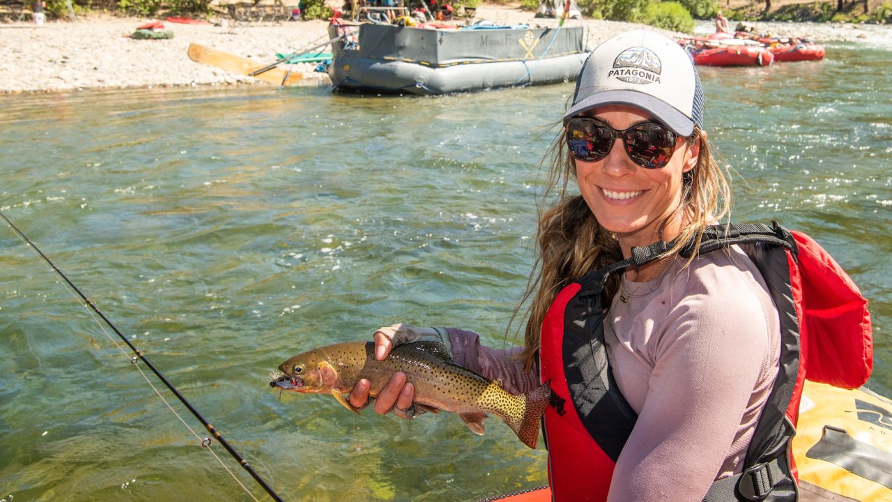 Woman holding a fish while on a rafting and fly fishing trip on the Middle Fork Salmon River