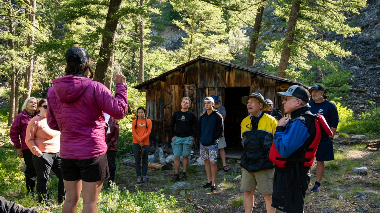 ROW Guides' carry a strong tradition of storytelling and interpretive guiding. group standing the the woods by old cabin