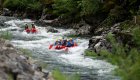 Upstream shot of two red rafts moving downstream through a narrow section of the St. Joe river in Northern Idaho