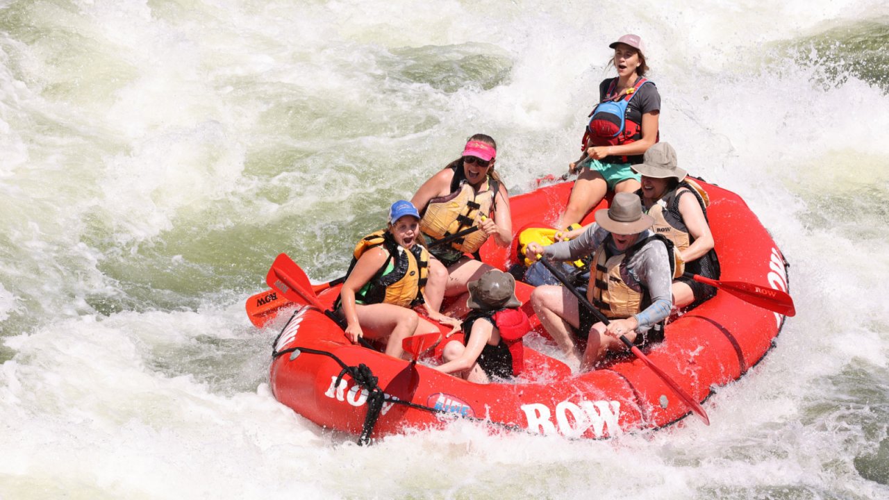 Hang on and get ready for a wild ride! red raft navigating white rapids on the clark fork river