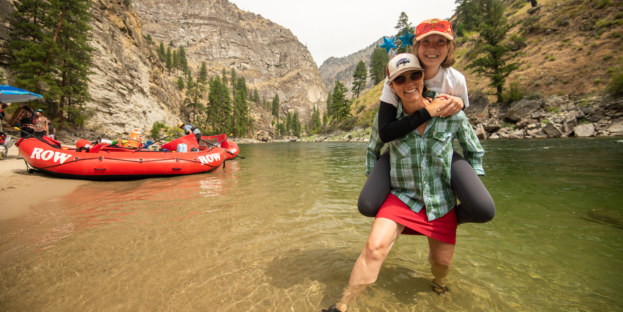 Mom and daughter standing in the river smiling 