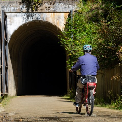 A man biking into a tunnel on a north Idaho rails to trails biking tour.