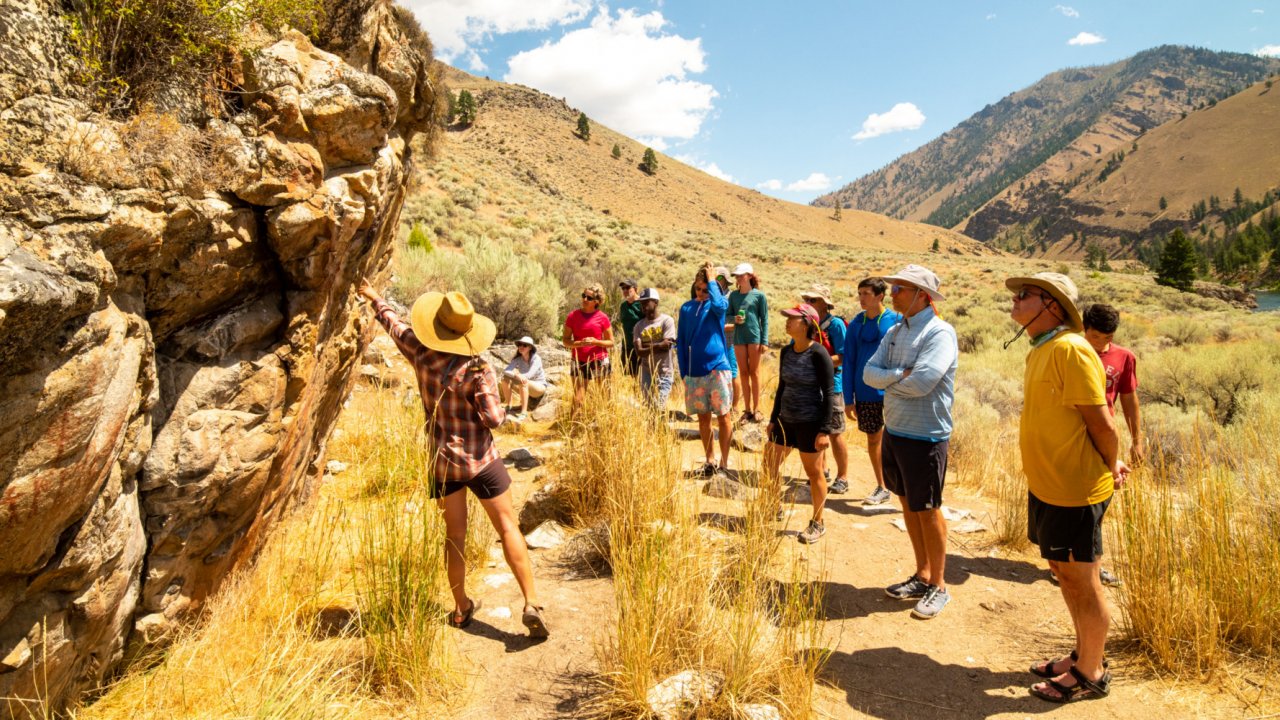 a group of rafters looking at rock art in Idaho