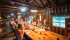 A group of hikers having a meal inside of a Rogue River lodge after a day of hiking.
