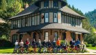 Group of cyclists posing with colorful bikes in front of the historic Wallace train station in Idaho