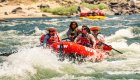 Smiling group rafting through rapids on a salmon river white water rafting Idaho adventure.