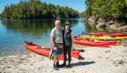 Happy kayakers smiling on the beach
