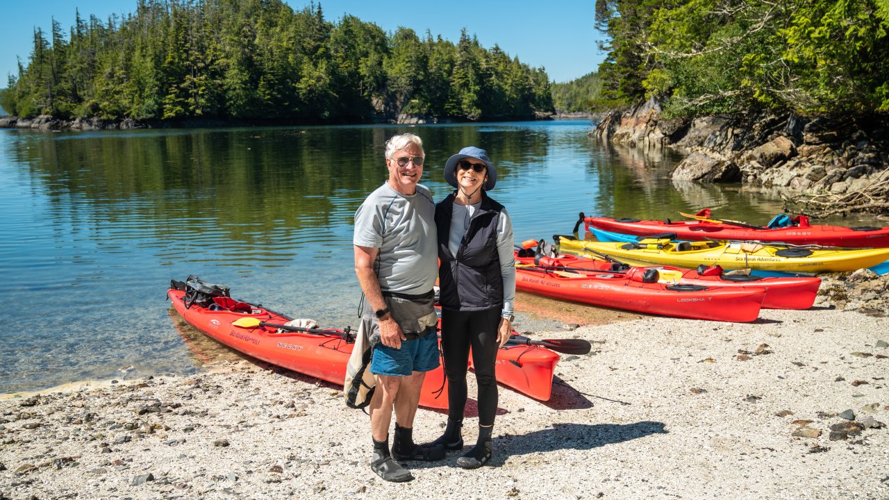 Happy kayakers smiling on the beach