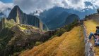 A group of people sitting at Machu Picchu observing and admiring 