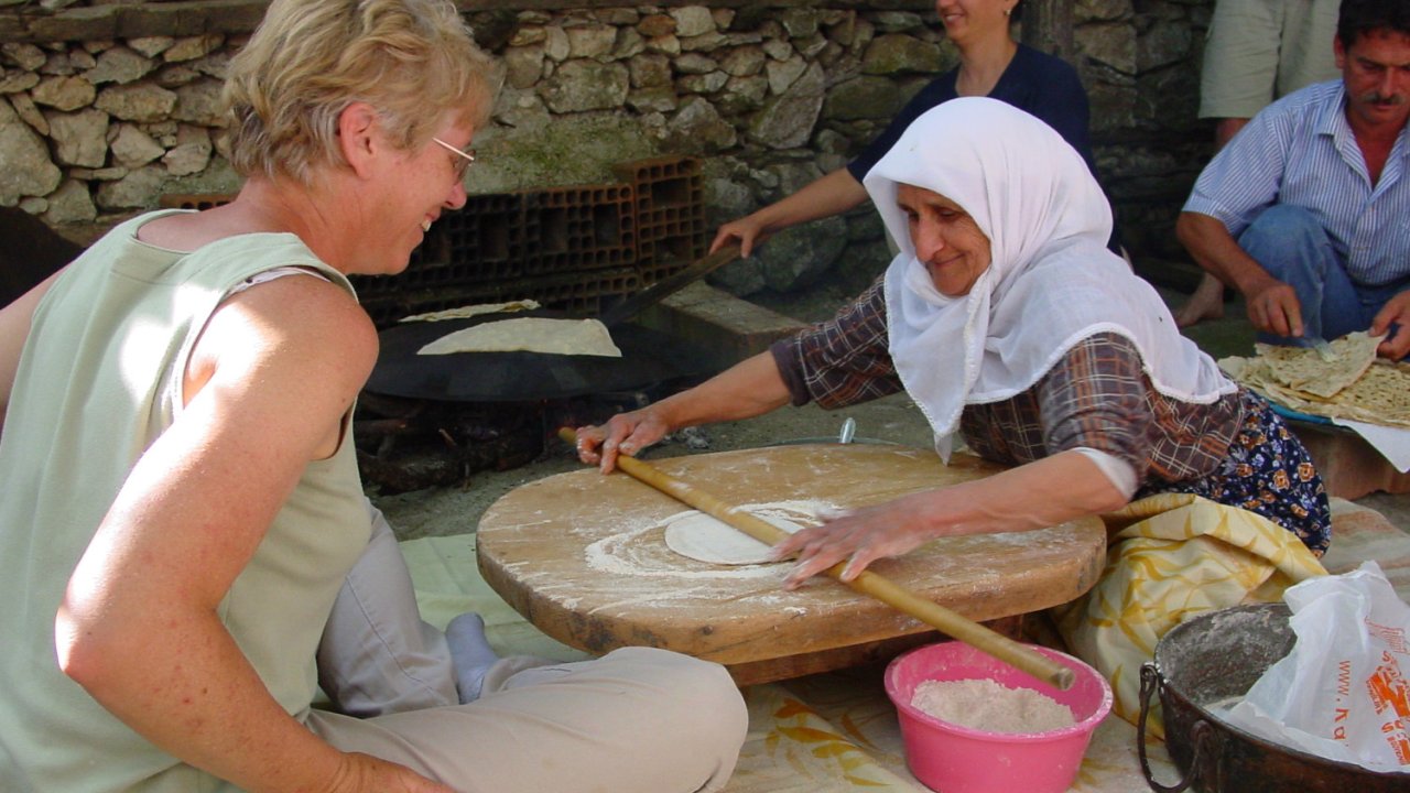 A Turkish woman explaining to another woman tourist how to make Turkish food
