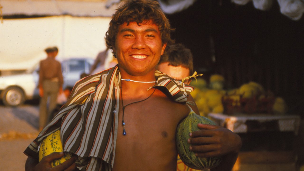 Turkish Boy with a unbuttoned button up smiling at sunset