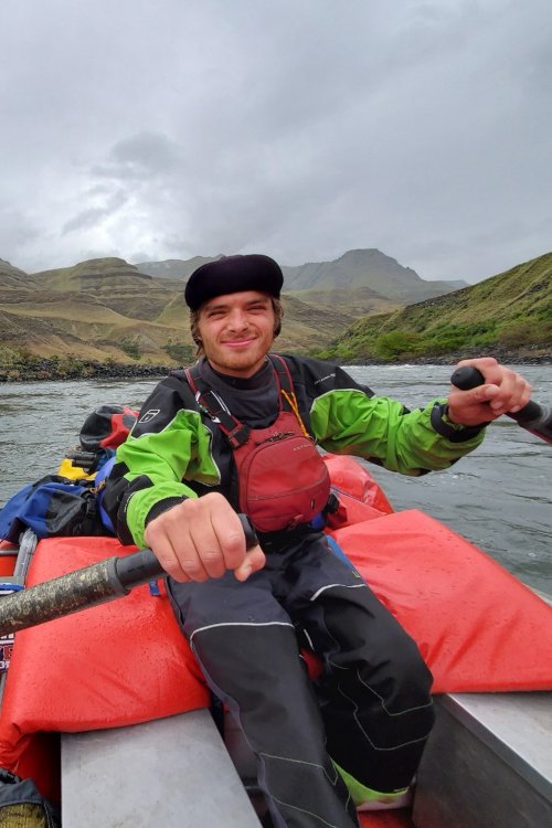 man rowing a raft down a river